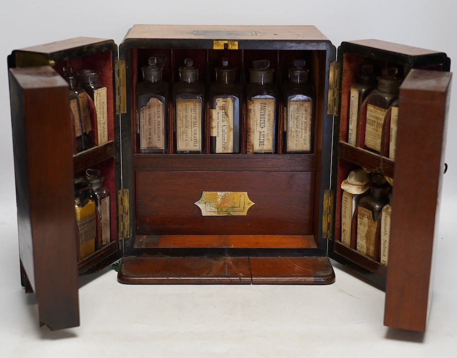 A late Victorian mahogany apothecary chest, containing a number of labelled glass bottles with preparations by James Woolley Sons and Co, Pharmaceutical Chemists, 28.5cm high, 25.5cm wide, 21cm deep. Condition - poor to